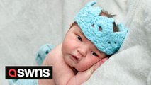 Adorable footage shows one of the first babies born under the reign of King Charles III wearing a woolly CROWN