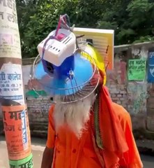 A man solar panel and fan installed on his head. एक व्यक्ति ने अपने सर पर सोलर पैनल और पंखा लगाया है।