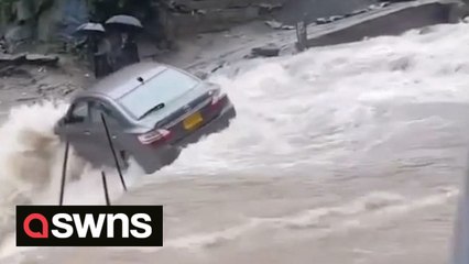 Driver's lucky escape after car swept away by floodwaters while crossing water-filled road