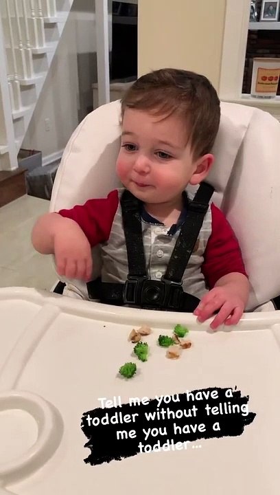 Sneaky toddler tries to hide his broccoli