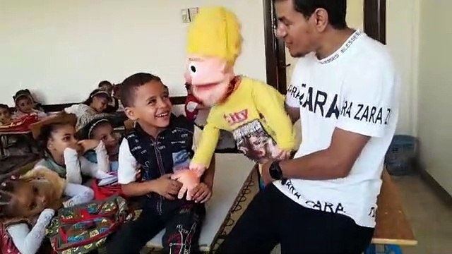 بيتكلم من بطنه.. الحسن شاب قناوي يشارك التلاميذ فرحتهم بالعرائس في أول يوم دراسى