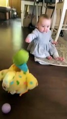Baby utterly shocked at toy hen laying eggs