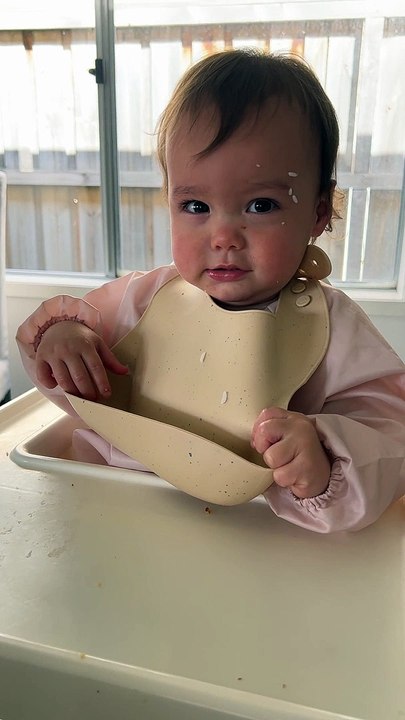 Baby Tries to Take Her Bib Off