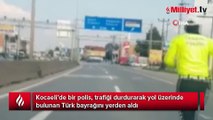 Yere düşen bayrak için trafiği durdurdu