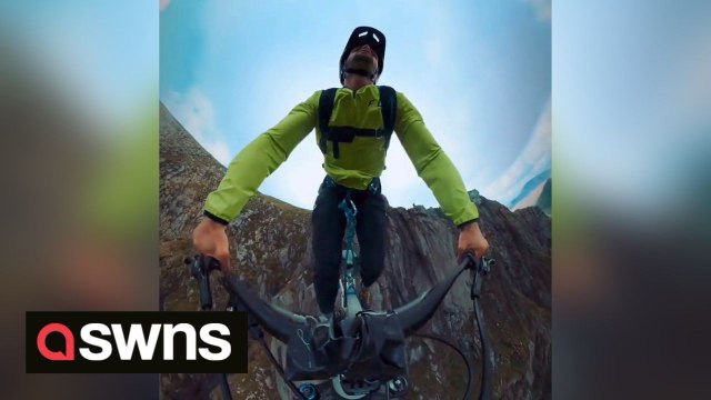 360 camera shows adrenaline junkie ride bike off a cliff in daring base jump stunt