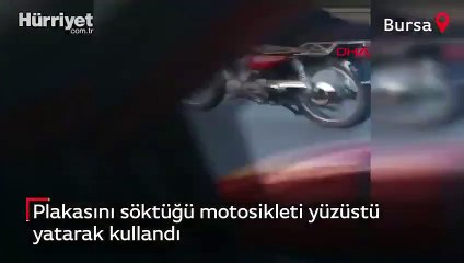 Plakasını söktüğü motosikleti yüzüstü yatarak kullandı