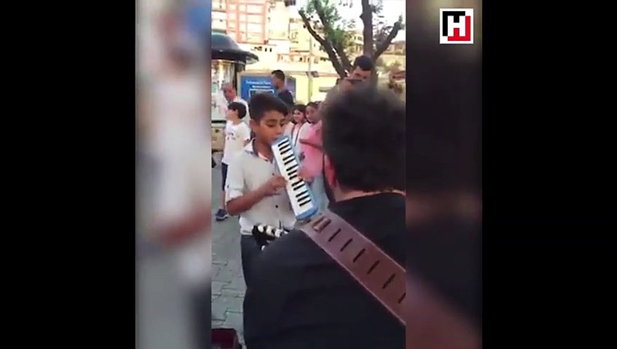 Üsküdar'da enstrümanı ile sokak sanatçılarına eşlik eden çocuk