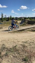 Boy rides bike up wooden ramp but forgets to pull up and falls forward