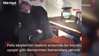 Polis ekiplerinin baskını sırasında bir kişinin, uyuyor gibi davranması kameralara yansıdı.
