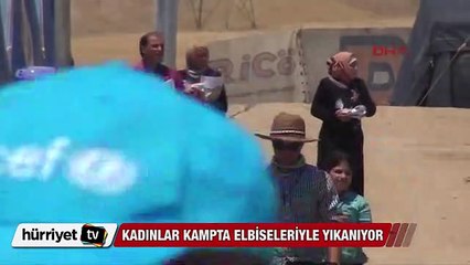 Mülteci kadınlar kampta elbiseleriyle yıkanıyor