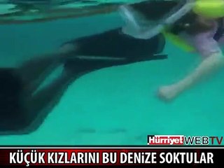 KÜÇÜK KIZLARINI KÖPEK BALIKLARIYLA DOLU DENİZE SOKTULAR