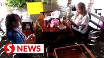 Flooded Thai noodle stall buzzing with customers