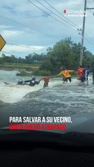 Lección de vecindad: formaron una cadena humana para salvar a un motociclista de una inundación