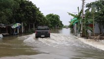 Trucks drive on submerged road as flooding continues in Thailand