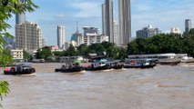 5 tugboats pulling huge barge at Chao Phraya river in Bangkok Thailand