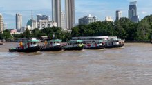 5 tugboats pulling huge barge at Chao Phraya river in Bangkok Thailand