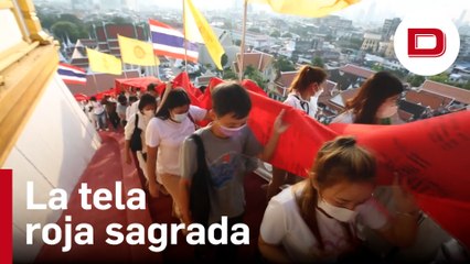 Devotos budistas participan en la ceremonia de la tela roja sagrada