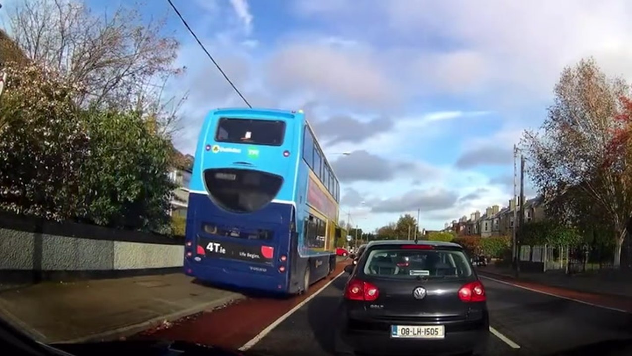 Double-decker bus drives on pavement to overtake queue of traffic