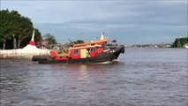 2 tugboats pulling a huge barge at Chao Phraya river Koh Kret island Thailand