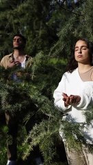 Couple Doing Yoga while Standing Beside the Tree