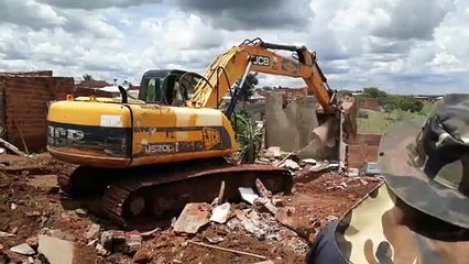 Derrubada das casas afetadas de vazão da bacia de contenção de Águas