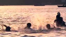 Boys having fun splashing around in the river Ganges, Varanasi