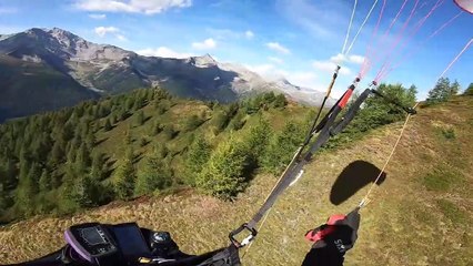 Person Paraglides Over Expanse of Green Mountains