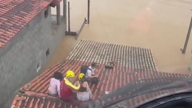 Firefighters rescue stranded residents from rooftops after heavy flooding in Brazil