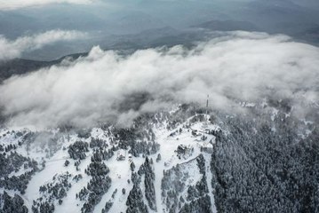 Uludağ'ın yeşil örtüsü sis altında kar beyazıyla bütünleşti