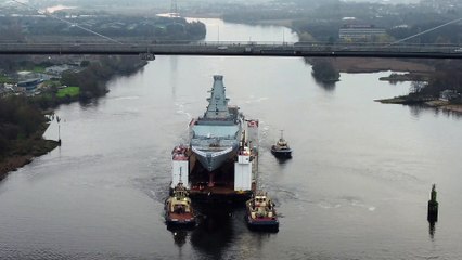 HMS Glasgow on a submergible barge being towed down the Clyde on her way to Geln Mallan on Loch Long