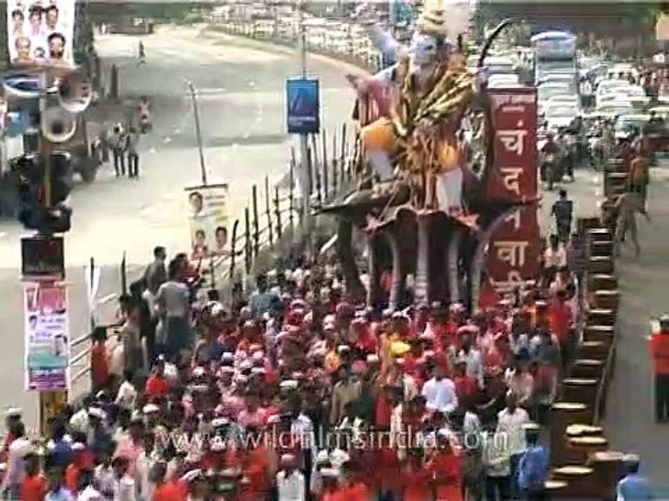 Ganesha devotees walk through busy traffic with the Ganesha Idol