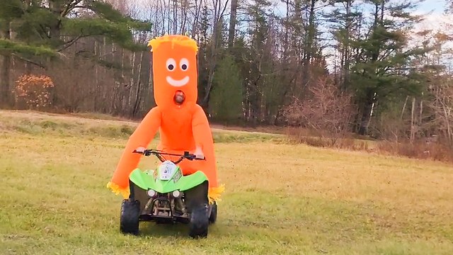 Wacky Inflatable dude riding a Quad Bike tries to pop a Wheelie!