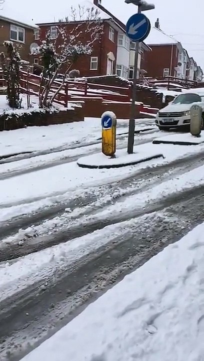 Un automobiliste prend le risque de doubler sur une rue enneigée en pente