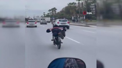 Yüzüstü yatarak motosiklet sürdü... Herkesin canını tehlikeye attı