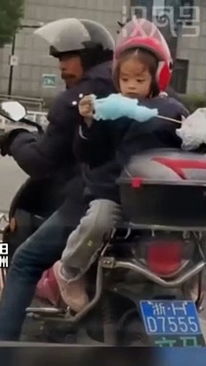 Ngồi sau xe, cô bé không quên chia sẻ miếng kẹo bông gòn cho cha: Sau lưng cha là bình yên