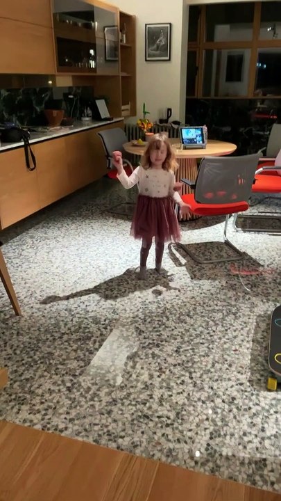 Woman grabs toy with her toes/feet then kicks it and accidentally hits little girl on her face