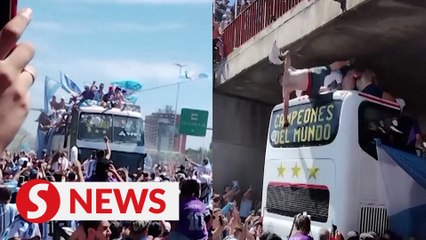 Fans jump onto Argentina players' bus, one falls