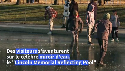 Des visiteurs arpentent le plus grand miroir d'eau de Washington, gelé par la tempête