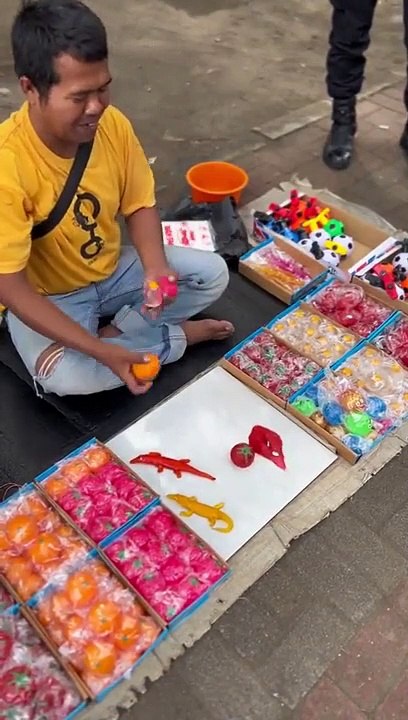 Des enfants sont  émerveillés par le spectacle d'un vendeur ambulant