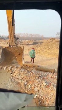 Thấy cụ bà vất vả đập trụ lấy sắt vụn, anh chàng lái máy xúc liền “tiện tay” giúp đỡ