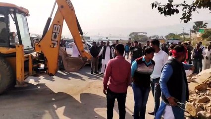 जेसीबी से धार्मिक स्थल की तोड़ी गई चारदीवारी का मलबा हटाया