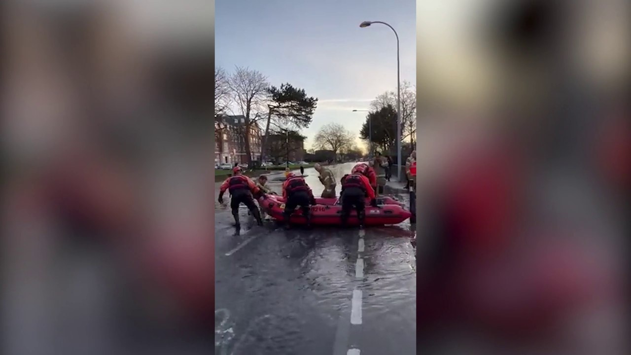 Residents ferried across the road in a boat after burst water main outside fire station