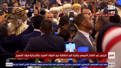 الرئيس السيسي يوقع على صورة لإحدى المواطنين خلال احتفالية عيد الميلاد المجيد