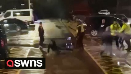 Shocking footage shows a police officer pushing a football fan to the ground