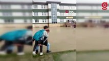 Okul bahçesi sular altında kaldı, öğrenciler birbirini sırtladı
