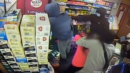 Trio of masked robbers threaten female shop worker with axe during terrifying raid