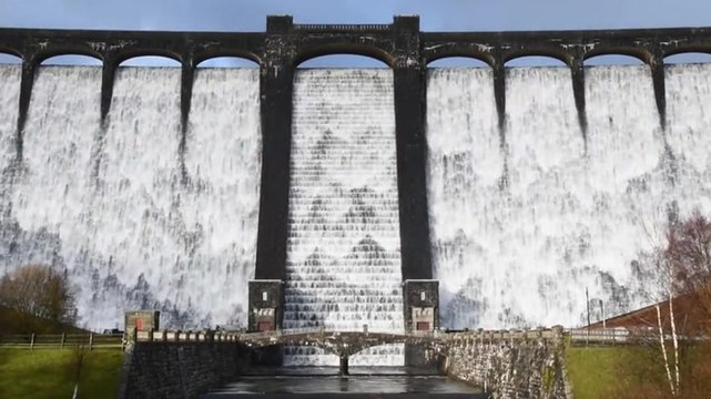 Water streams down overflowing Welsh dam following heavy rain