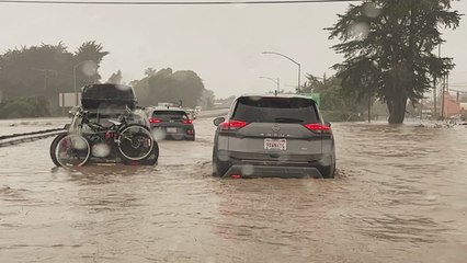 Woman genuinely concerned about her car stalling while driving through flood water