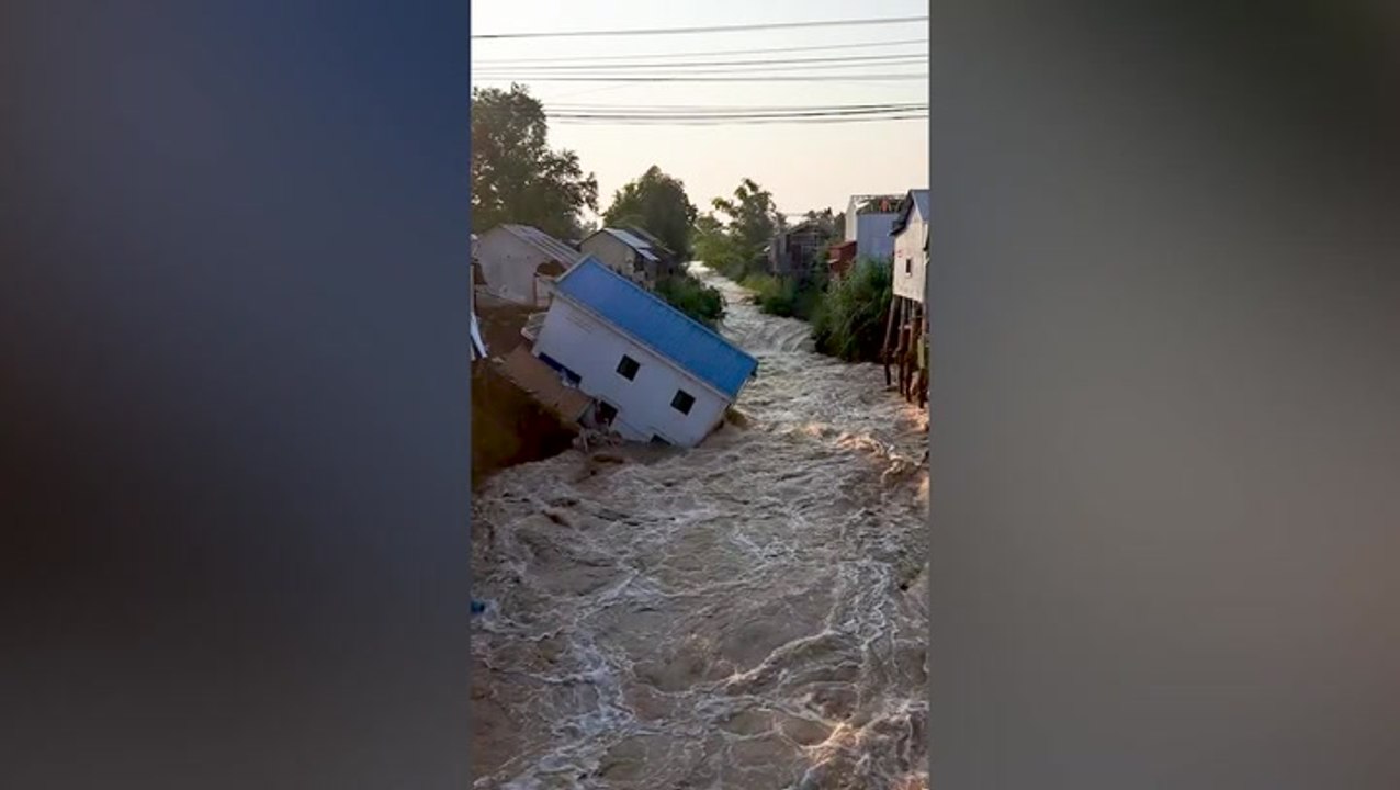 Moment house collapses into canal after flash flooding in Cambodia