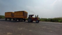 Indian tractor. Hindustan tractor transporting cutting sugarcane from field to sugar factory. Hindustan tractor at uphill . Heavy Indian tractor